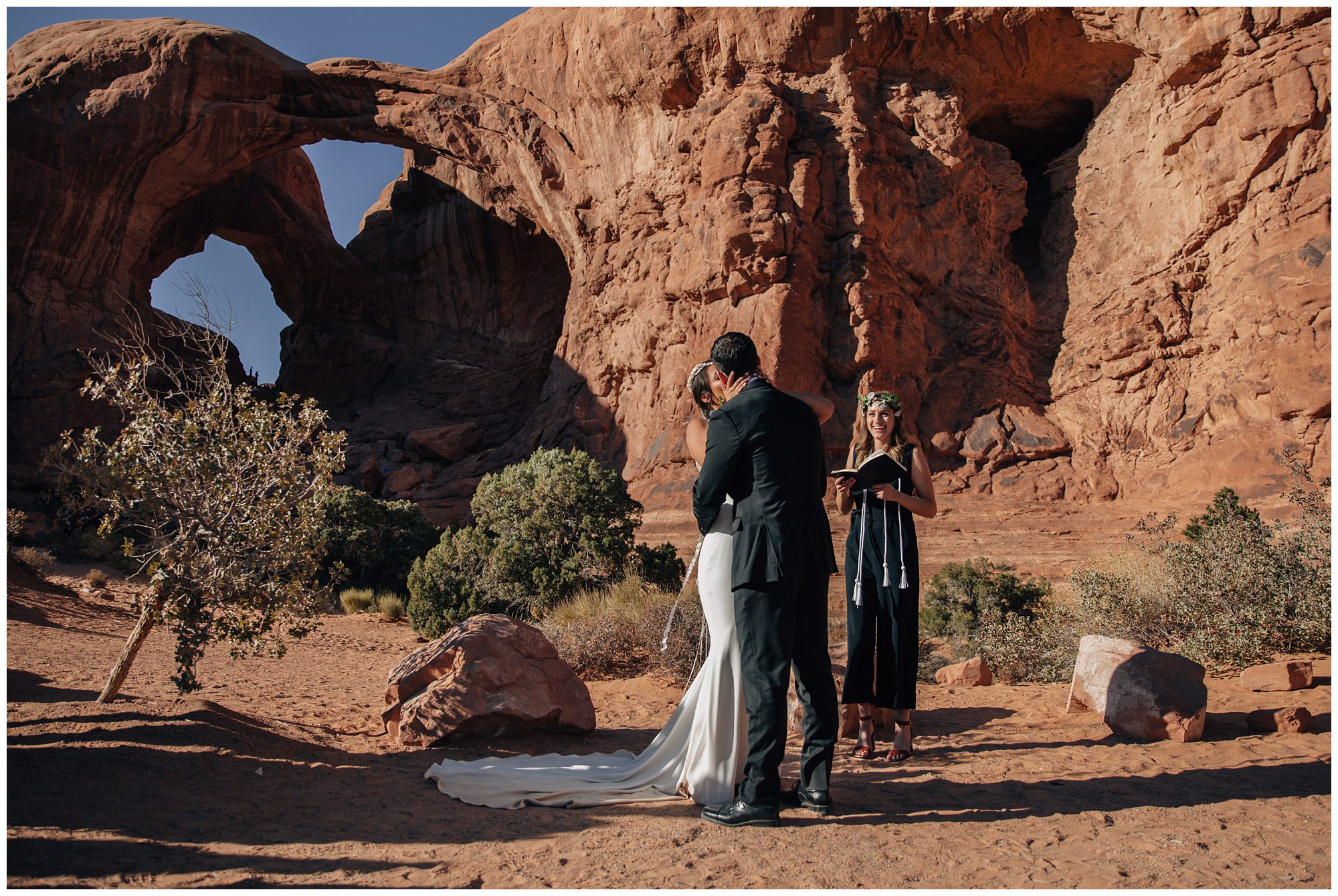 Bride and Groom share their first kiss in front of Double Arch at Arches National Park.